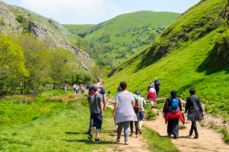 A group of people walking through an area of the Peak District. style=